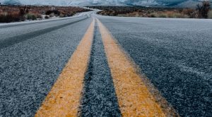 An asphalt road covered in a light snowfall.